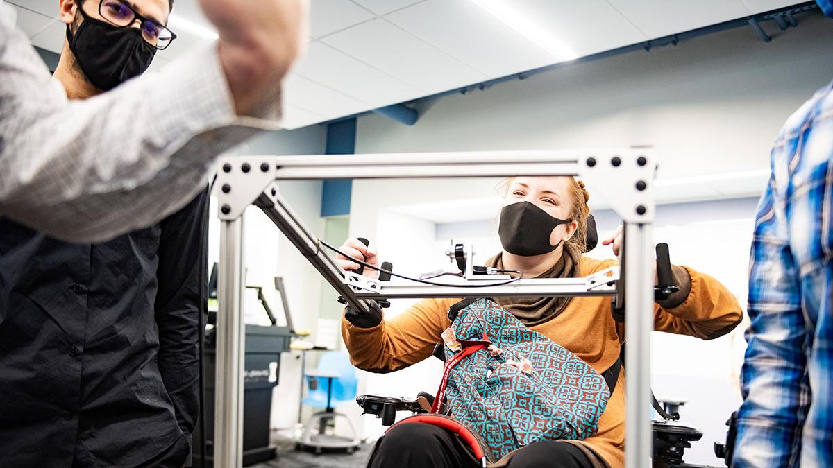 A WWAMI Medical Education Program student, who uses a wheelchair, test the assistive CPR device developed by College of Engineering students.